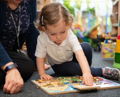 A Rookwood Nursery pupil playing with an educational toy with a staff member.