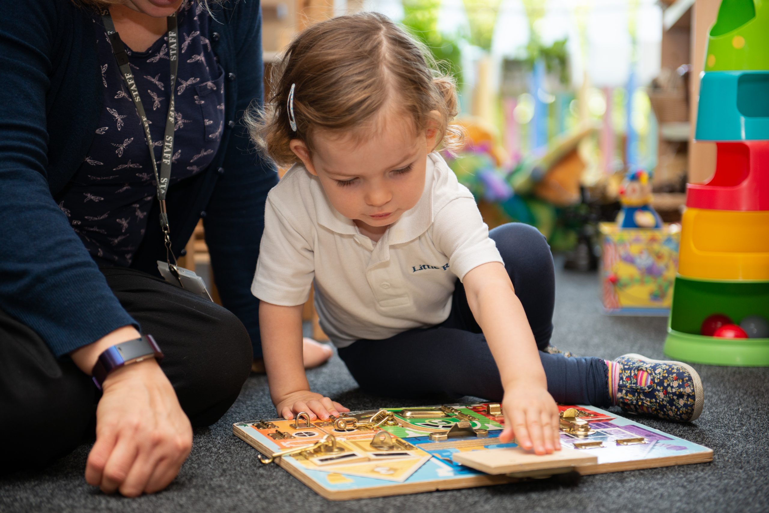A Rookwood Nursery pupil playing with an educational toy with a staff member.