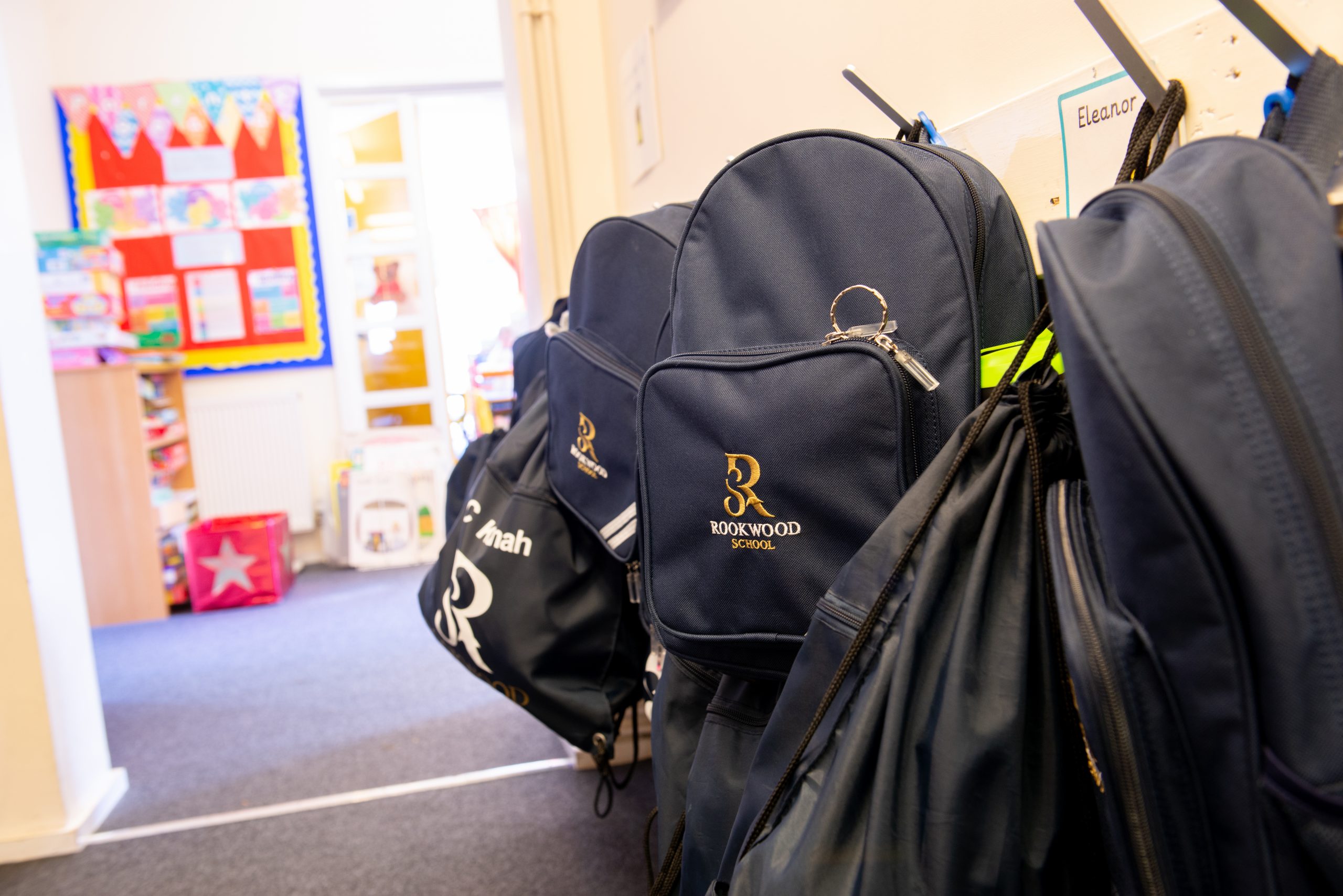 Rookwood School branded bags hung up on coat pegs