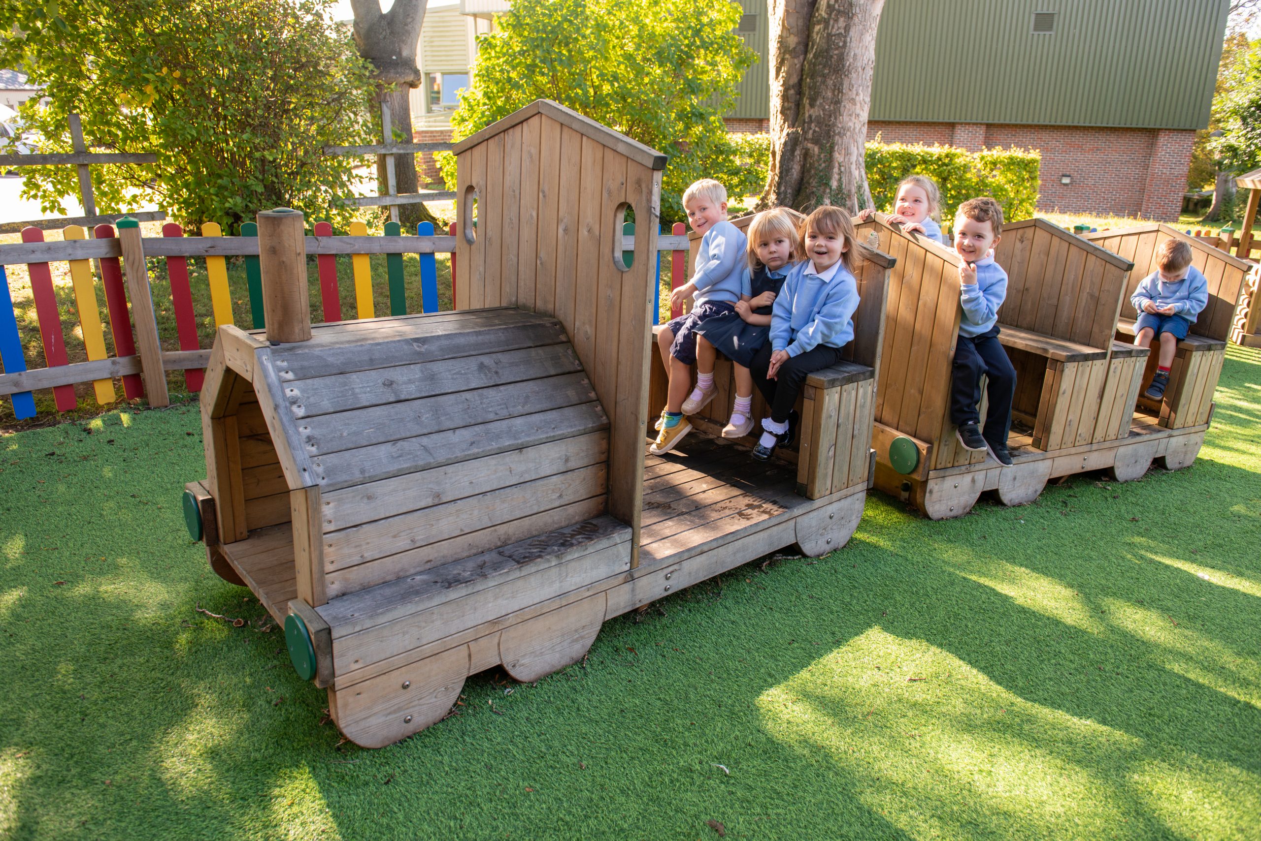 Rookwood nursery children playing on outdoor play equipment shaped like train.