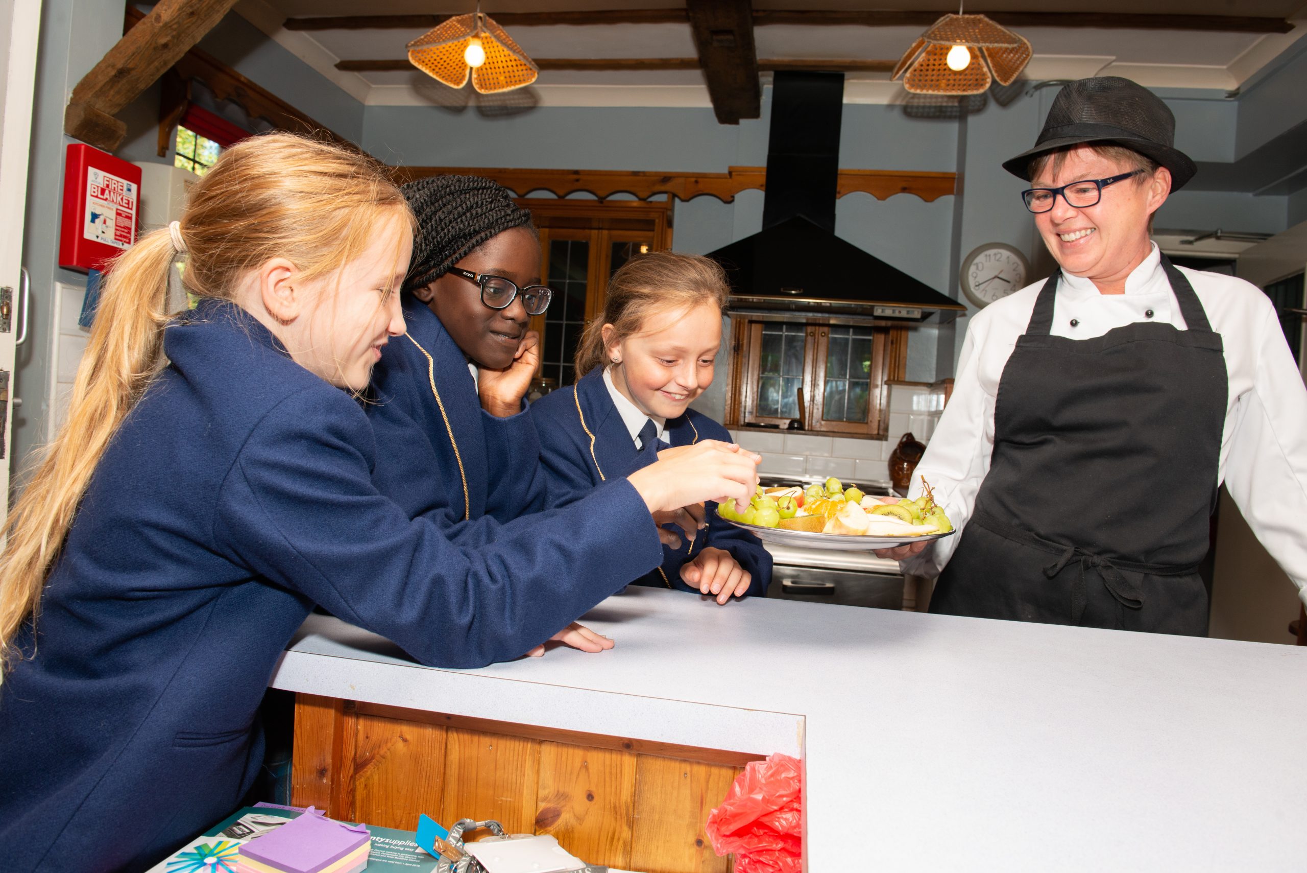 Three Rookwood boarding school students are being served food by the friendly Rookwood School staff.