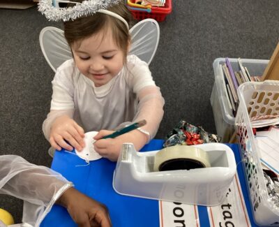 Reception child writing on label