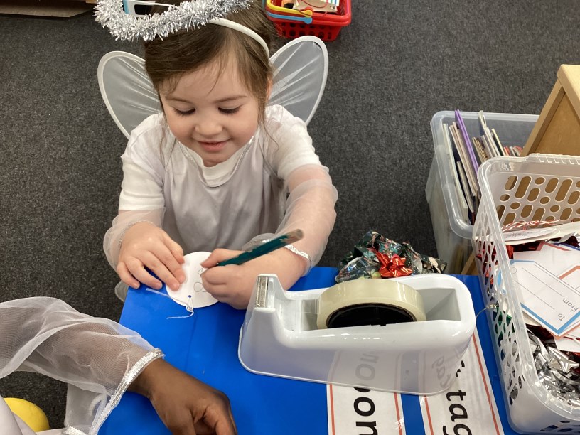 Reception child writing on label