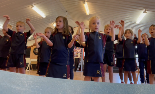 Children from different year groups signing the lyrics to "What a Wonderful World" in British Sign Language during Activity Week.