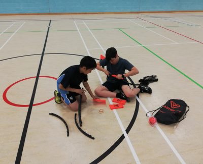 Rookwood School students setting up equipment in a sportshall.