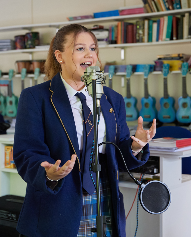 Pupil singing into microphone