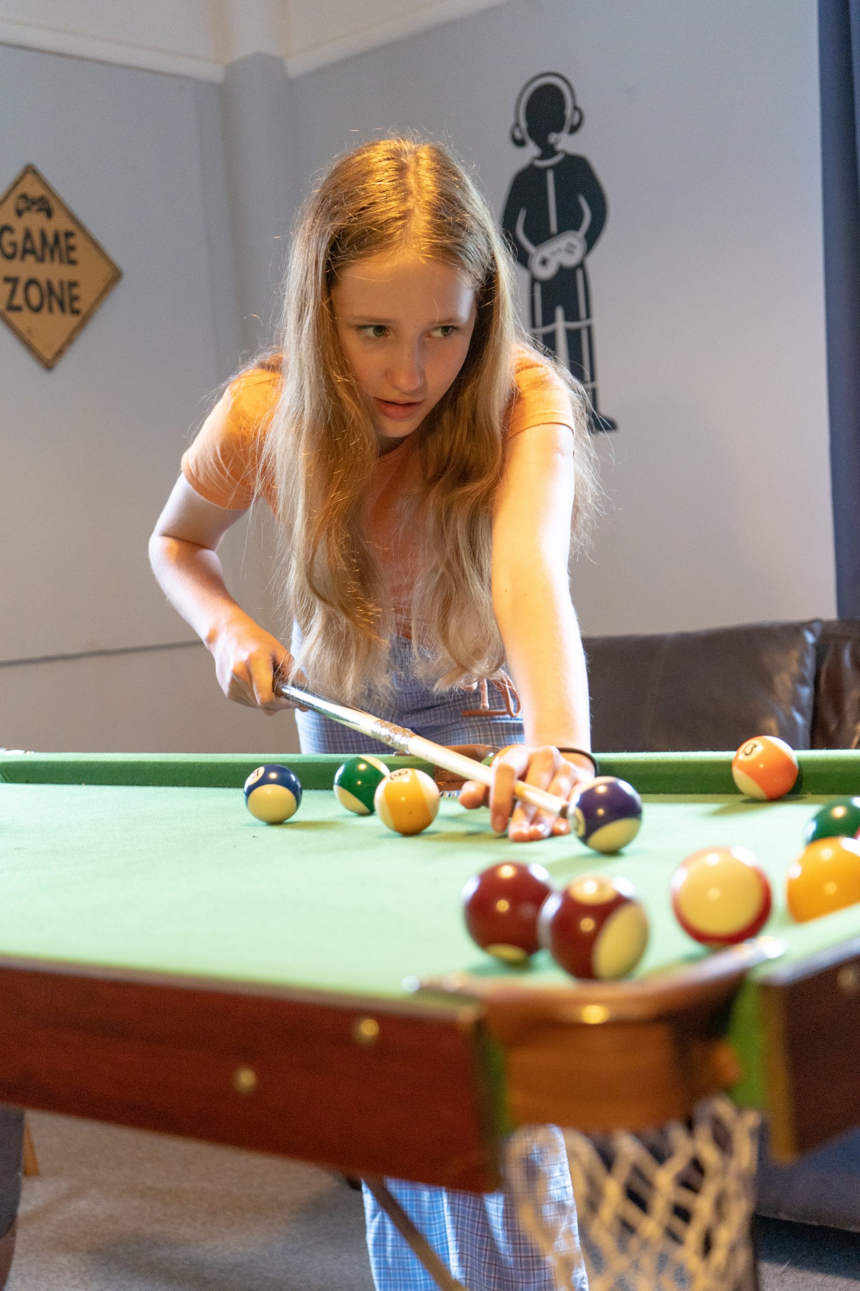 A Rookwood School boarding student is playing pool in the evening in the boarding accommodation.