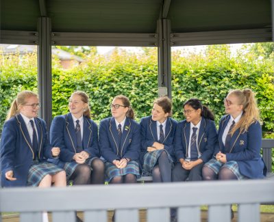 A group of Rookwood School secondary students sit in an outdoor space talking.