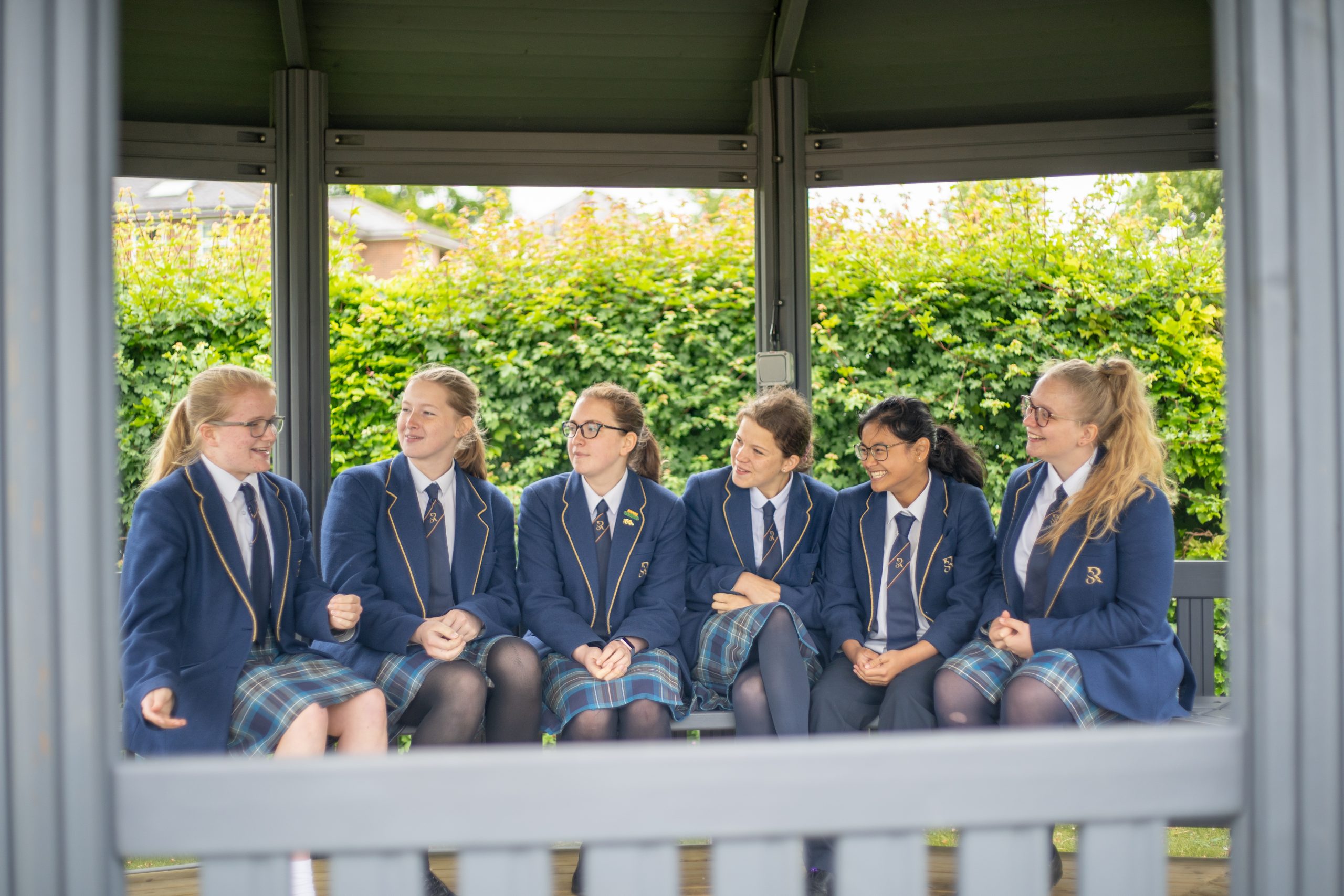 A group of Rookwood School secondary students sit in an outdoor space talking.