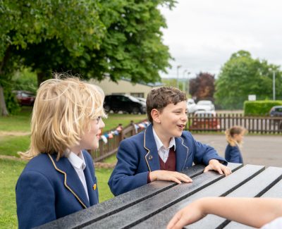 Rookwood's prep school students chatting on a bench at playtime.