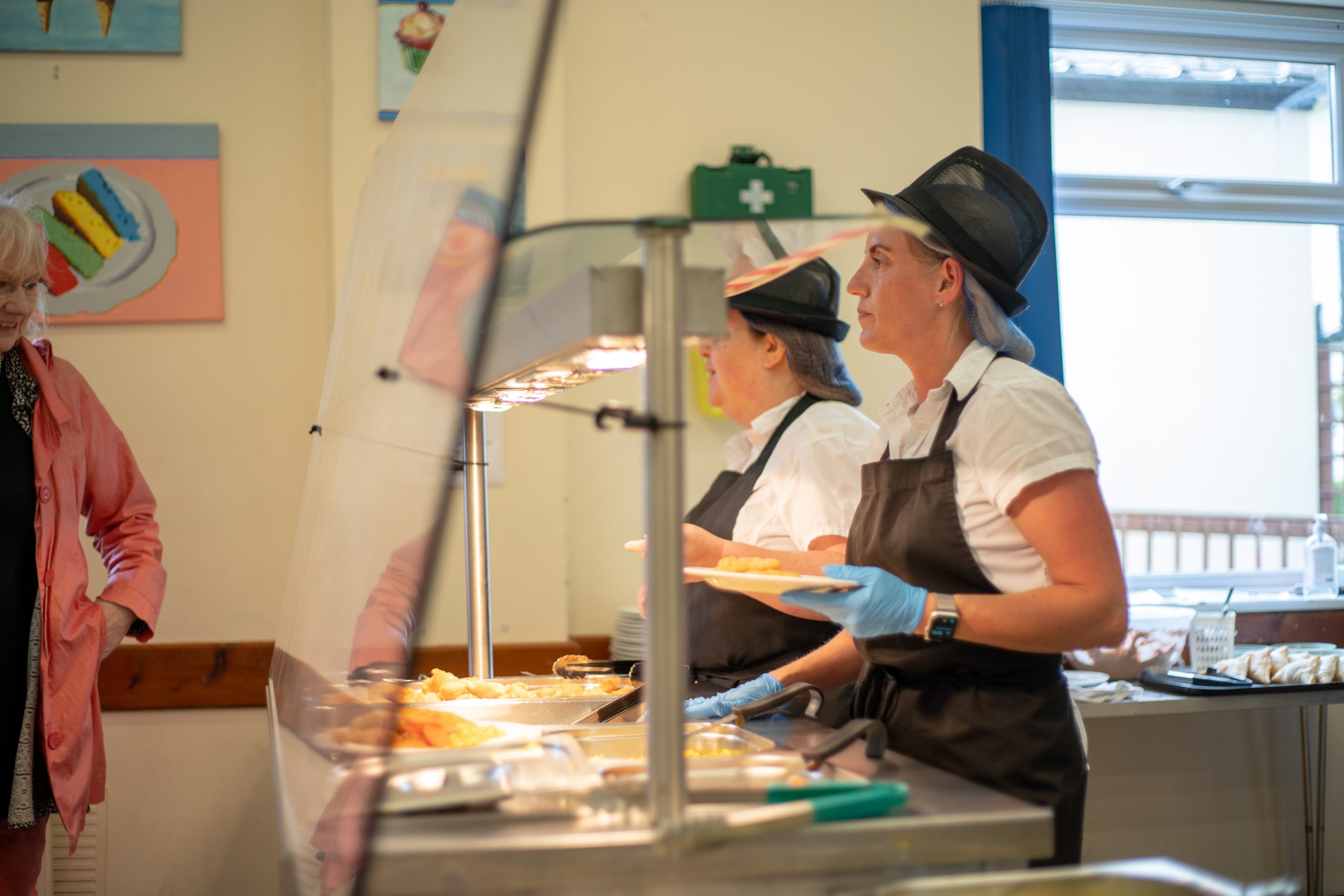 Rookwood School staff serve hot lunch food in the dining area.